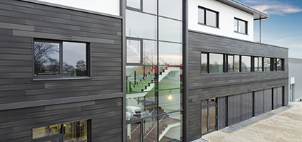 Modernes Haus mit grau-weiss verkleideter Fassade